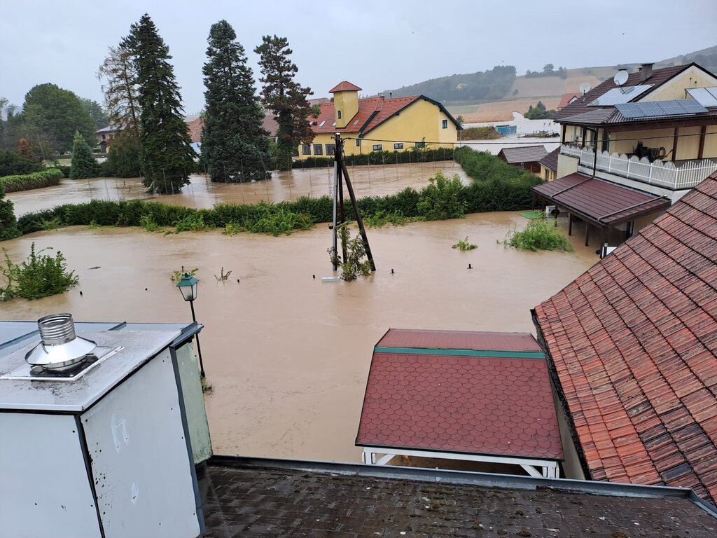 Eine Straße steht unter Wasser, einige Häuser schauen nur zum Teil aus dem Wasser hervor.